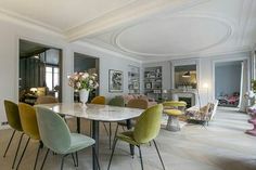 a dining room table surrounded by colorful chairs