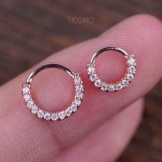 a pair of small hoop earrings with clear stones on the inside and outside of them