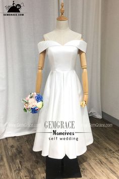 a white wedding dress on display in front of a curtain with the words, gengarce