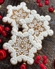 two decorated cookies sitting on top of a cooling rack