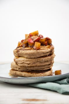 a stack of pancakes with bacon on top