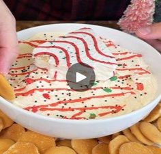 someone is decorating a cake with icing and sprinkles in a bowl