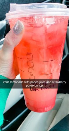 a person holding up a pink drink in their hand with the caption'veni lemonade with peach juice and strawberries, puree on top