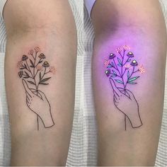 two tattoos with flowers on their arms, one is holding the other's hand