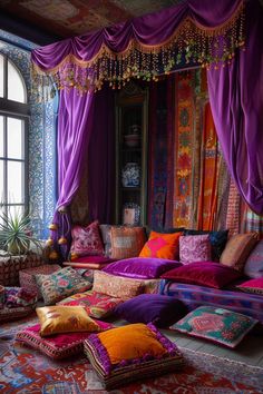 a living room filled with lots of colorful pillows and furniture covered in purple drapes