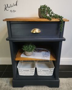 a black shelf with two baskets and a potted plant on top