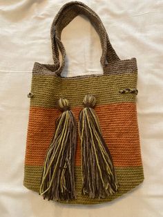 an orange and green bag with tassels on it