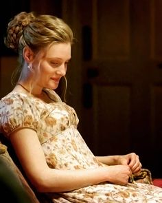 a woman sitting on top of a couch in a dress