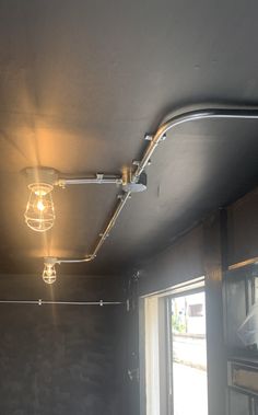 a light fixture is hanging from the ceiling in a room with dark walls and wood flooring