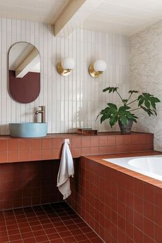 a bath room with a sink and a bath tub next to a mirror on the wall