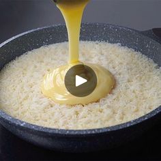 a pan filled with rice and sauce being poured into it