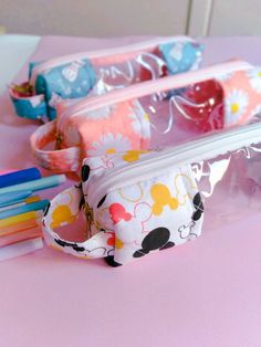 several pencils and makeup bags sitting on a table