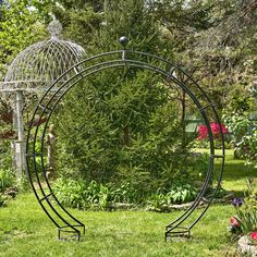 an iron circular garden decoration in the middle of a yard