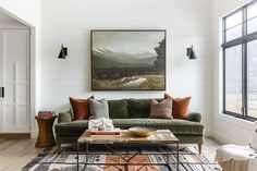 a living room filled with furniture and a painting hanging on the wall above it's headboard