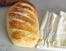 a loaf of bread sitting on top of a white plate next to a yellow and white napkin