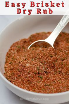 a white bowl filled with red seasoning next to a silver spoon and text overlay that reads easy brisket dry rub