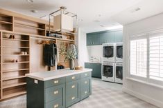 a laundry room with washer, dryer and cabinets next to eachother