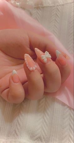 Pink nails with bow and pearl decals Beige Nails With Pearls, Pink Nails With Bow Charm, 3d Pearl Nails, Nails With Bows And Pearls, Nude Nails With Pearls, Pearl Charm Nails, Nail Designs With Pearls, Nails With Ribbon, Nails With Bow Charm