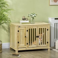 a small dog in a wooden crate next to a potted plant on the floor