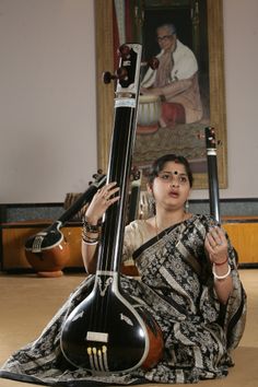 a woman sitting on the floor with her instrument