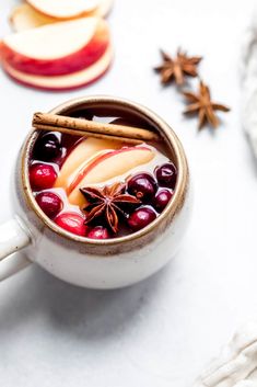 an apple cider is garnished with cinnamon, apples and star anise