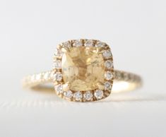 an engagement ring with a yellow diamond surrounded by white diamonds