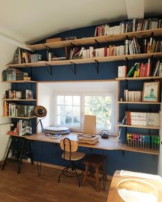 an office with bookshelves and desk in the corner