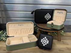 two green and black suitcases sitting next to each other on a wooden table with greenery in the background