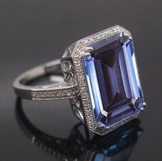 an image of a ring with a blue stone in the center and diamonds around it