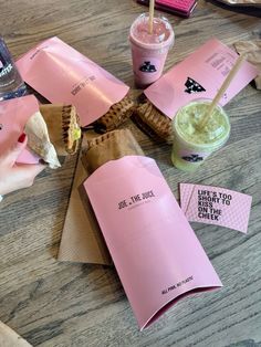 a table topped with pink paper and drinks