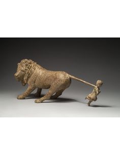 a bronze figurine of a lion and its baby on a gray background with an inscription