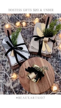 three wrapped gifts sitting on top of a wooden table next to candles and lights with the words, hostess gifts $ 20 & under