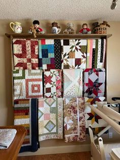 a wall hanging with many different quilts on it