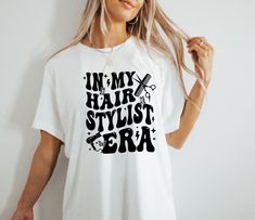 a woman wearing a t - shirt that says in my hair stylist era