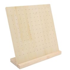 a wooden peg board with holes on the front and bottom, sitting against a white background