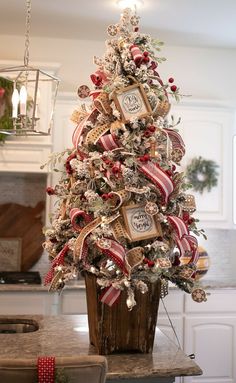 a decorated christmas tree sitting on top of a kitchen counter