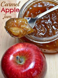 an apple is sitting next to a jar of caramel apple jam with a spoon in it