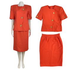 "Orange, lightly textured fabric suit set Collarless, short sleeve button down jacket with small welt pockets. Padded shoulders and fully lined.  Straight cut skirt with side seam pockets. Pegged waist buttons and zips in back. Fully lined. Vented back.  condition: excellent  color(s): orange  fabric(s): shells - 65% polyester, 35 % rayon | linings - 100% polyester  brand: Kasper  care: dry clean  estimated size: Medium (marked 12, please check measurements) ✩ size is estimated - please check me Classic Spring Skirt Suit With Buttons, Spring Short Sleeve Skirt Suit For Work, Semi-formal Spring Sets With Buttons, Spring Semi-formal Sets With Buttons, Retro Workwear Sets For Spring, Retro Spring Workwear Sets, Formal Summer Sets With Buttons, Semi-formal Spring Sets With Button Closure, Spring Semi-formal Sets With Button Closure