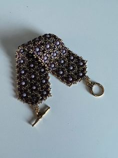 a close up of a metal object with beads on it's end and a key chain attached to it