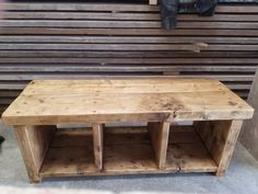 a wooden bench sitting in front of a wall