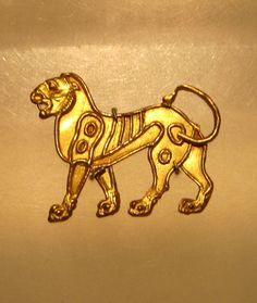 a gold colored pin with a dog on it's chest and an eye patch in the shape of a lion