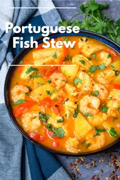 a bowl filled with shrimp and potatoes next to cilantro on top of a table