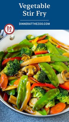 vegetable stir fry with broccoli, carrots and peppers in a white bowl