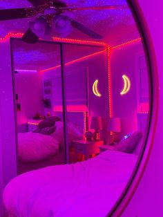 a bedroom with purple lights and a bed in the corner, as seen through a round mirror