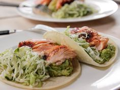 two fish tacos are sitting on a plate