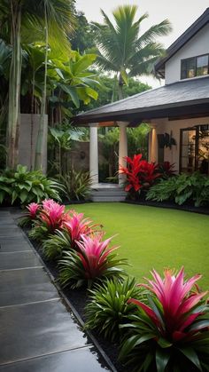 a house with lush green grass and pink flowers in the front yard, surrounded by palm trees