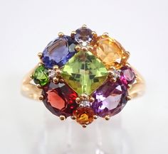 14K Yellow Gold Multi Color Gemstone and Diamond Ring. This ring is set with one Cushion Cut Peridot in the center.  This peridot measures 6 X 6 mm.  There are four Oval gemstones set around the center.  These Ovals are: Amethyst, Garnet, Citrine and Tanzanite.  There are also natural Round Gemstones, these are: Iolite, Tsavorite, Garnet and Citrine.  The Round Brilliant Diamond accents in this ring are also set in the corners of the center gem.  These diamonds are H color, I clarity.  This ring is 14KT Yellow Gold, weighs 3.9 grams and is a finger size 8, which can be resized (please inquire about sizing with the finger size you need). This ring will be accompanied by an appraisal by a GIA Certified Diamond Grader with the retail replacement value of $1,485.00. I will ship this ring promp Oval Multi-stone Peridot Gemstones, Anniversary Multi-stone Peridot Gemstones, Elegant Multi-stone Peridot Gemstones, Diamond Right Hand Ring, Right Hand Ring, Tsavorite Garnet, Right Hand Rings, Hand Ring, Ring Ideas