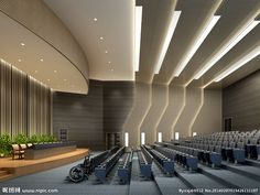 an empty auditorium with rows of seats and plants