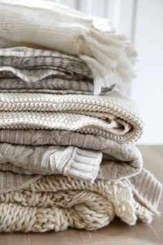 a pile of blankets sitting on top of a wooden table