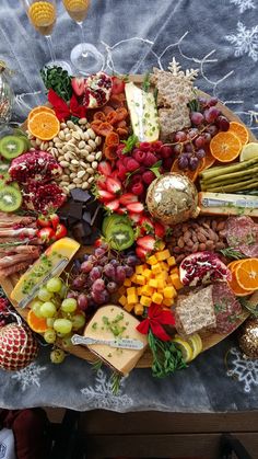 a table topped with lots of different types of cheeses and fruit on top of it